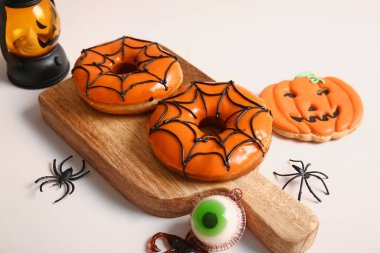 Cadılar Bayramı için tahtadan tatlı çörekler. İçinde şeker, kurabiye ve bej arka planda örümcekler var.