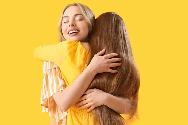 Młode Siostry Przytulające Się Żółtym Tle — Zdjęcie stockowe