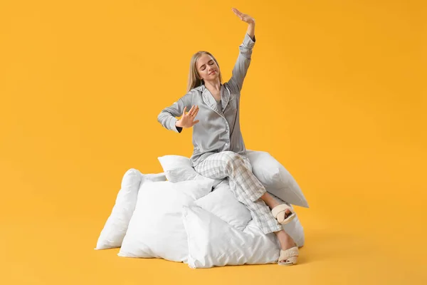 Jovem Sonolenta Pijama Sentada Travesseiros Contra Fundo Amarelo — Fotografia de Stock