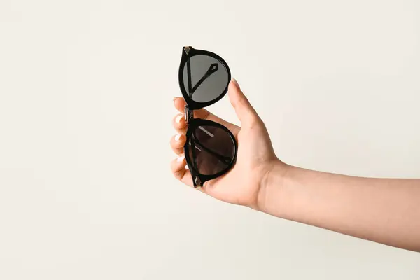 Mão Feminina Segurando Óculos Sol Elegantes Fundo Branco — Fotografia de Stock