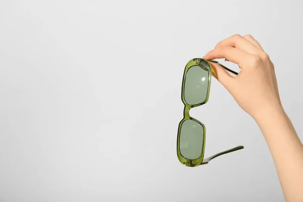 Mão Feminina Segurando Óculos Sol Elegantes Fundo Branco — Fotografia de Stock