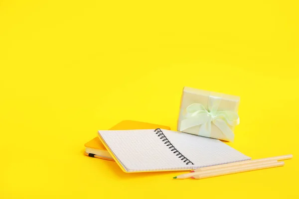 装有笔记本和黄色背景彩笔的礼品盒 — 图库照片