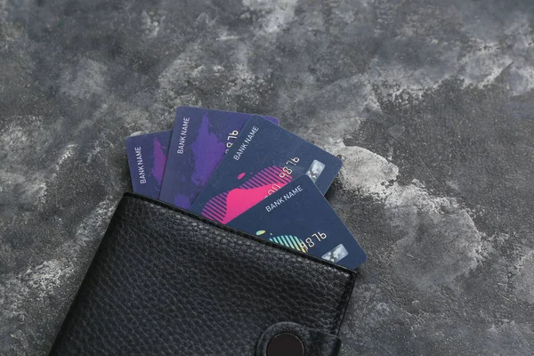 Leather wallet with many credit cards on grunge black background