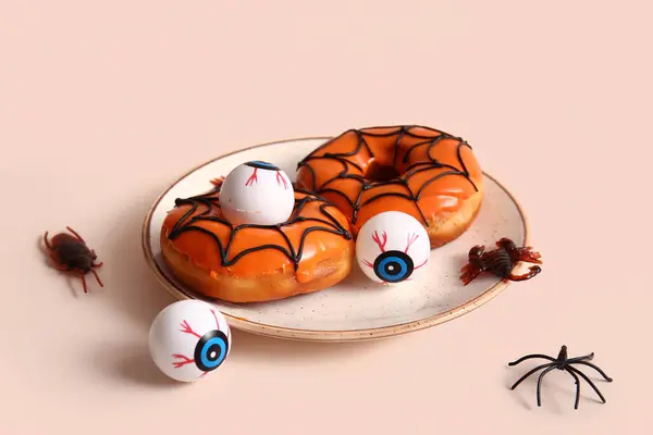 베이지색 배경에 거미와 할로윈에 맛있는 도넛의 — 스톡 사진