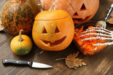 Tahta masaya oyulmuş balkabağı ve Cadılar Bayramı süslemeleri.