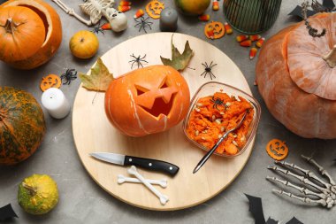 Gri grunge masasına oyulmuş balkabağı ve Cadılar Bayramı süslemeleri