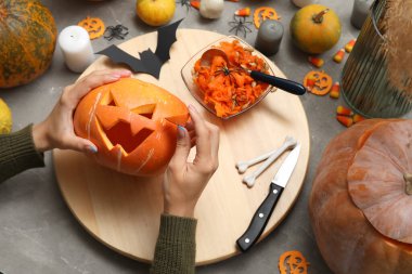 Gri grunge masasında oyulmuş Cadılar Bayramı kabağı olan kadın.