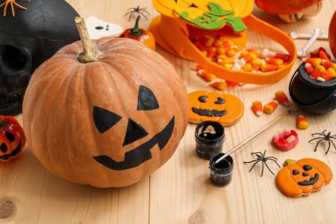 Ahşap masada boyanmış balkabağı ve Cadılar Bayramı süslemeleri