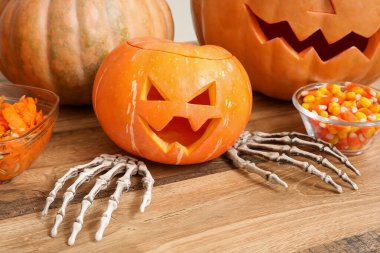 Ahşap masaya iskelet ellerle oyulmuş Cadılar Bayramı balkabağı