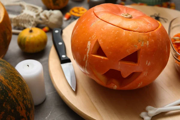 Gri grunge masasına oyulmuş balkabağı ve Cadılar Bayramı süslemeleri