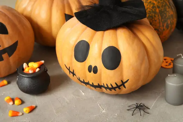 Painted pumpkins and Halloween decorations on grey grunge table