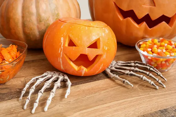 Ahşap masaya iskelet ellerle oyulmuş Cadılar Bayramı balkabağı