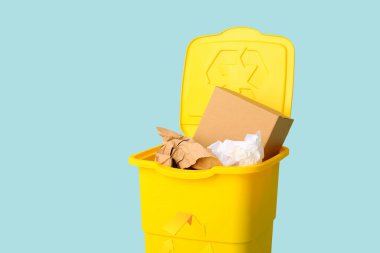 Açık mavi arka planda kağıt olan çöp konteynırı. Geri dönüşüm kavramı