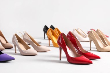 Gri arka planda çok farklı yüksek topuklu ayakkabılar.