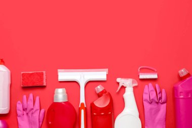 Kırmızı arkaplanda farklı temizlik malzemeleri