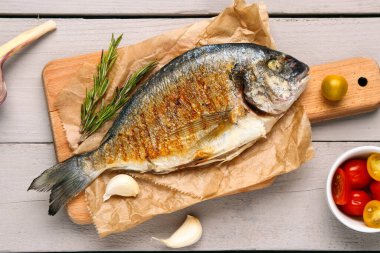 Hafif ahşap arka planda ızgara Dorado balığı.