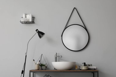 Lavabolu masa, banyo aksesuarları ve banyoda ayna.