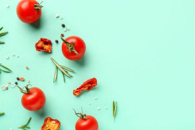 Olgun vişneli domates, kurutulmuş biber ve turkuaz arka planda biberiye karışımı.