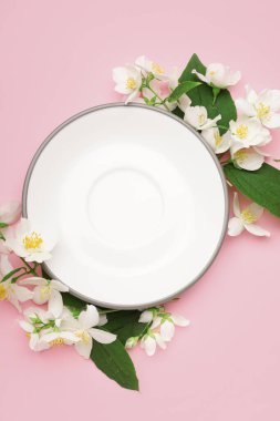 Tabaklı kompozisyon ve pembe arka planda güzel yasemin çiçekleri.