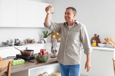 Mutfakta yağı olan olgun bir adam.