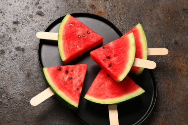 Koyu arkaplanda tatlı karpuz çubukları olan tepsi