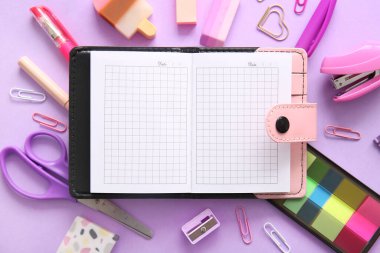 Boş defter ile kompozisyon ve mor arkaplan üzerinde farklı okul sayfası, yakın plan