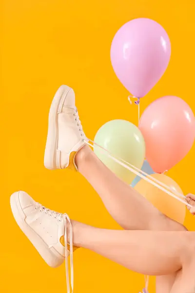 Young Woman Tying Shoes Laces Balloons Yellow Background — Stock Photo, Image