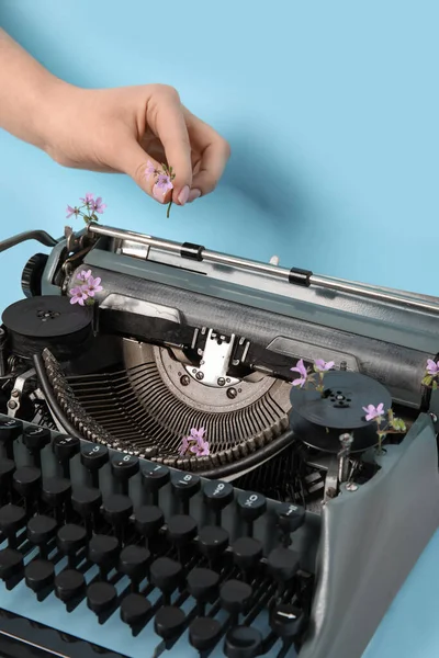 Vrouw Putting Lila Bloem Vintage Typemachine Blauwe Achtergrond — Stockfoto