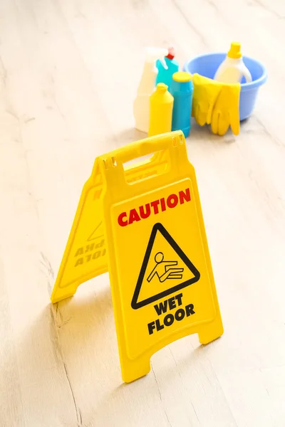 Caution sign on wet floor in room, closeup