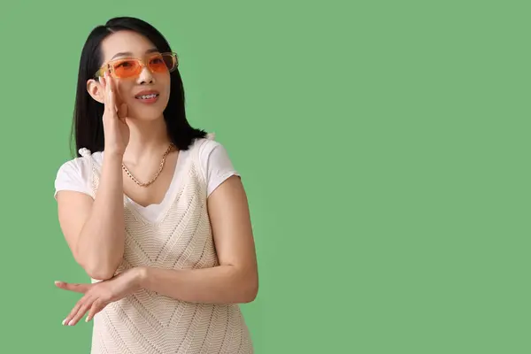 Piękna Azjatka Stylowych Okularach Przeciwsłonecznych Zielonym Tle — Zdjęcie stockowe