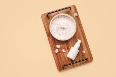 Tahta tahta tahta tahta, arka planda vücut ovalama kavanozu ve kozmetik ürünü var.