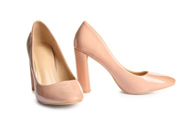 Beyaz arka planda bej renkli yüksek topuklu ayakkabılar.