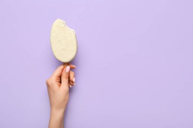 Lezzetli çikolata kaplı dondurmayı leylak arka planda tutan kadın.