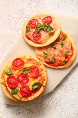 Beyaz arka planda farklı lezzetli mini pizzalar olan tahta