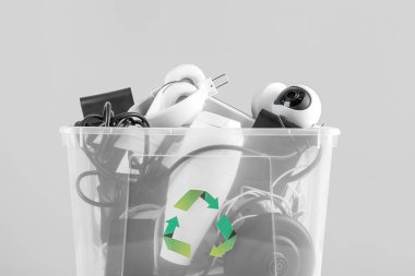 Gri arka planda farklı ev aletleri olan geri dönüşüm kutusu