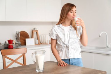 genç kadın mutfakta içme sütü