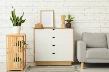 Çekmeceleri, kanepesi ve rafları olan aydınlık oturma odasının içinde.