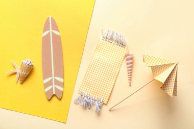 Renkli arka planda mini sörf tahtası, şemsiyesi ve plaj battaniyesi olan yaratıcı bir yaz kompozisyonu