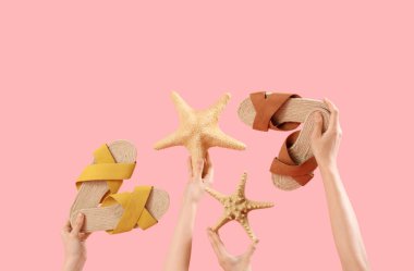 Parmak arası terlikli eller ve pembe arka planda deniz yıldızları