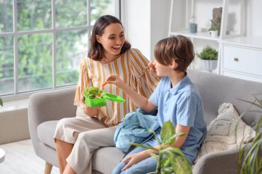 Anne, küçük oğlunun sırt çantasında beslenme çantasını hazırlıyor.