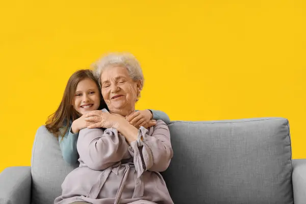 Menina Com Avó Abraçando Fundo Amarelo — Fotografia de Stock