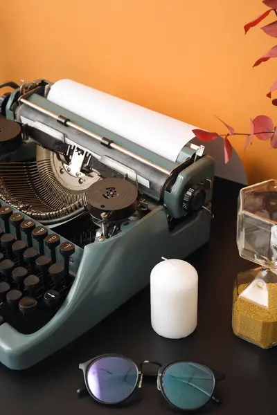 Vintage Schrijfmachine Met Zandloper Kaars Zonnebril Zwarte Tafel Bij Oranje — Stockfoto