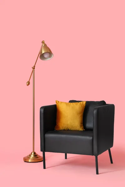 Czarny Fotel Poduszką Lampą Różowym Tle — Zdjęcie stockowe