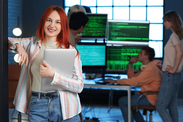 Female programmer with laptop in office