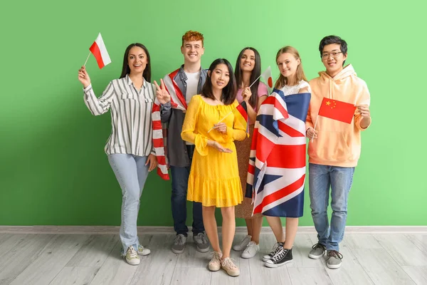 Jovens Estudantes Escola Idiomas Com Bandeiras Perto Parede Verde — Fotografia de Stock