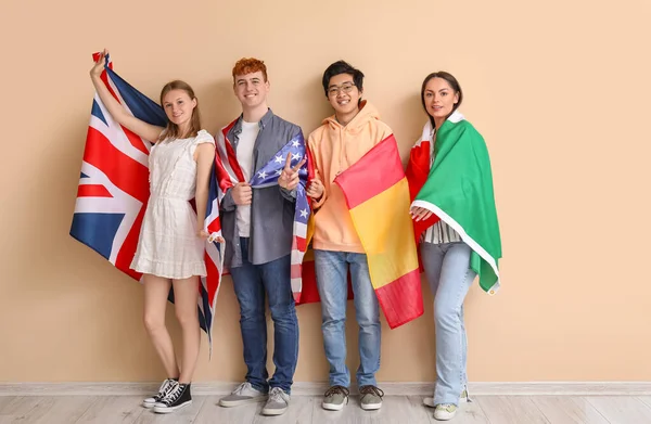 Jóvenes Estudiantes Escuela Idiomas Con Banderas Cerca Pared Beige — Foto de Stock