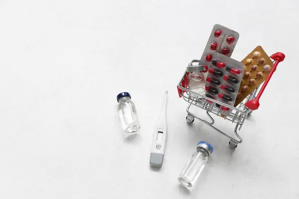 白色背景不同药丸的微型购物车 — 图库照片