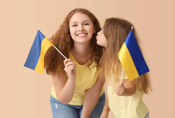 Happy Little Girl Kissing Her Mother Ukrainian Flags Beige Background — Stock Photo, Image