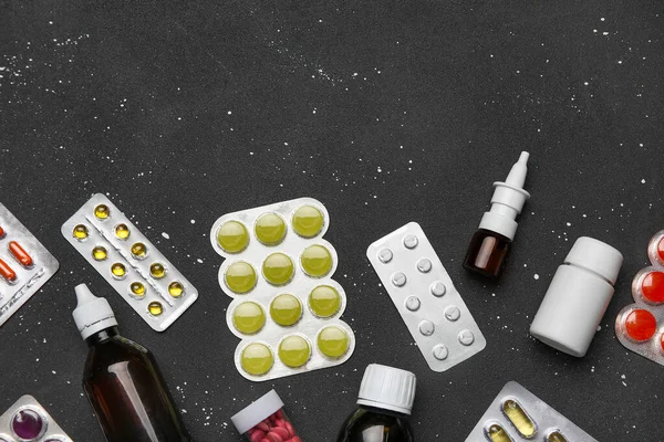Different pills and bottles of medicines on black background