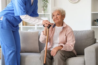 Evde sopa ve hemşiresi olan yaşlı bir kadın.